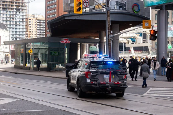 Toronto, ON, Kanada - 24 Ekim 2025: Parlayan acil durum ışıkları olan bir polis aracı şehir merkezindeki kavşakta duruyor.