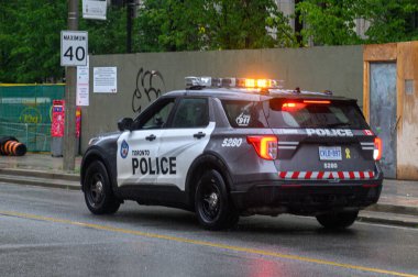 Toronto, ON, Kanada - 24 Ekim 2025: Turuncu ışıkları yanıp sönen Toronto Polis SUV ıslak bir şehir caddesinde devriye geziyor