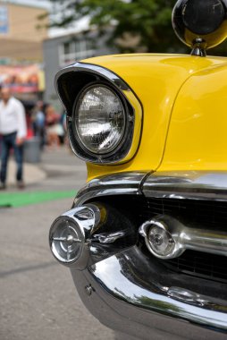 Toronto, ON, Kanada - 24 Ekim 2025 Klasik sarı bir Chevrolet arabasının ön ucu şehrin caddesinde park halinde duruyor.