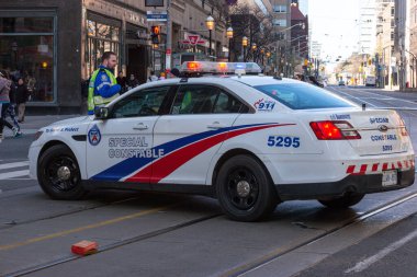 Toronto, ON, Kanada - 24 Ekim 2025: Şehrin bir caddesinde parlayan acil durum ışıkları olan beyaz bir özel polis arabası durduruldu.