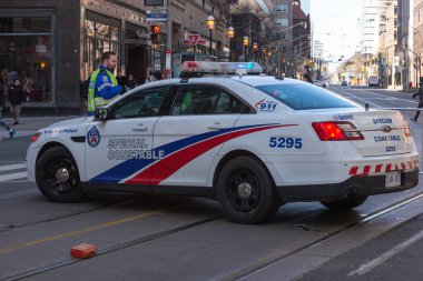 Toronto, ON, Kanada - 24 Ekim 2025: Şehrin bir caddesinde parlayan acil durum ışıkları olan beyaz bir özel polis arabası durduruldu.
