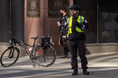 Toronto, ON, Kanada - 24 Ekim 2025: Arka planda Hudson 's Bay Company binasının bulunduğu finans bölgesinde bir Toronto polisi görev yapıyor.