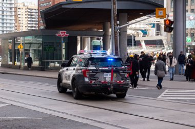 Toronto, ON, Kanada - 24 Ekim 2025: Parlayan acil durum ışıkları olan bir polis aracı şehir merkezindeki kavşakta duruyor.