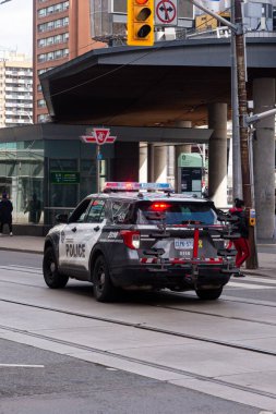 Toronto, ON, Kanada - 24 Ekim 2025: Parlayan acil durum ışıkları olan bir polis aracı şehir merkezindeki kavşakta duruyor.