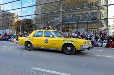 Toronto, ON, Kanada - 24 Ekim 2025: Klasik bir sarı metro polis arabası halka açık bir geçit töreninde şehir caddesinde ilerliyor.