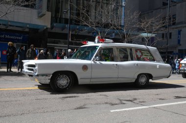 Toronto, ON, Kanada - 12 Ekim 2025: Beyaz antika bir acil durum aracı kaldırımdan izleyicilerin izlediği bir geçit töreninde şehir caddesinde ilerliyor.