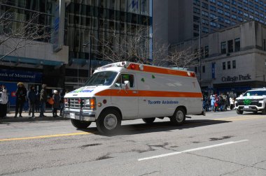 Toronto, ON, Kanada - 12 Ekim 2025: Beyaz ve turuncu bir Toronto ambulansı geçit töreninde bir şehir caddesinde ilerliyor.