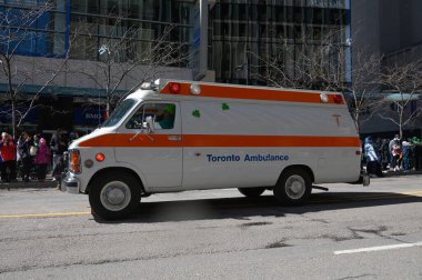 Toronto, ON, Kanada - 12 Ekim 2025: Beyaz ve turuncu bir Toronto ambulansı geçit töreninde bir şehir caddesinde ilerliyor.