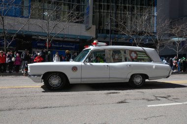 Toronto, ON, Kanada - 12 Ekim 2025: Beyaz antika bir acil durum aracı kaldırımdan izleyicilerin izlediği bir geçit töreninde şehir caddesinde ilerliyor.