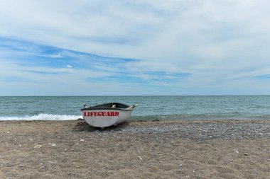 Toronto, ON, Kanada - 12 Ekim 2025: Beyaz bir cankurtaran botu denizin yanındaki çakıllı bir sahilde, güvenlik görevine hazır..