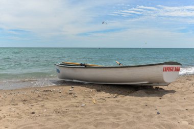 Toronto, ON, Kanada - 12 Ekim 2025: Beyaz bir cankurtaran botu denizin yanındaki çakıllı bir sahilde, güvenlik görevine hazır..