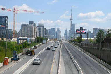 Toronto, ON, Kanada - 12 Ekim 2025: Şehir siluetine yaklaşan büyük bir otoyolda trafik akışı var..