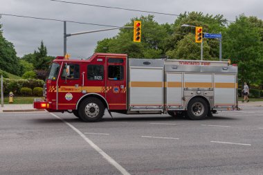 Toronto, ON, Kanada - 12 Ekim 2025: Parlak kırmızı bir Toronto İtfaiye aracı bir kavşağa doğru gidiyor..