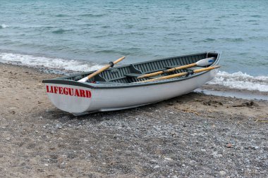 Toronto, ON, Kanada - 12 Ekim 2025: Beyaz bir cankurtaran botu denizin yanındaki çakıllı bir sahilde, güvenlik görevine hazır..