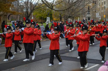 TORONONONONTO, ONTARIO, CANADA - 23, 2025: Özenle hazırlanmış kırmızı ve siyah üniformalı bir grup müzisyen, Orijinal Noel Baba Yürüyüşü güzergahında yürürken,