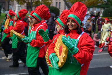 TORONONONONONTO, ONTARIO, CANADA - 23 Kasım 2025: Festivale katılan kırmızı ve yeşil şef / elf kostümleri, büyük kurabiye aksesuarları, gülümseyin ve Orijinal Noel Baba Yürüyüşü güzergahı boyunca yürüyün