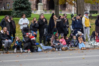 Toronto, ON, Kanada - 23 Kasım 2025: İzleyiciler 121 'inci Noel Baba Geçidi' ni yol kenarından, bayram etkinliği için sıcak giyimli bir şekilde izliyorlar..