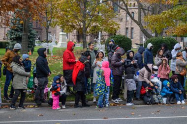 Toronto, ON, Kanada - 23 Kasım 2025: İzleyiciler 121 'inci Noel Baba Geçidi' ni yol kenarından, bayram etkinliği için sıcak giyimli bir şekilde izliyorlar..