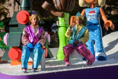 TORONONONONONTO, ONTARIO, CANADA - 23 Kasım 2025: LEGO Friends karakterlerinin büyük bir bölümünün yer aldığı renkli bir şamandıra, Toronto şehir merkezindeki The Original Santa Claus Parade 'den devam ediyor. Metalik kostümlü iki çocuk oturuyor. 