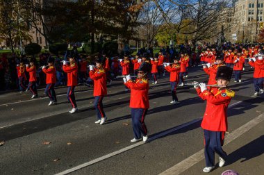 TORONONONONONTO, ONTARIO, CANADA - 23, 2025: Olağanüstü kırmızı (kırmızı) üniformalı ve uzun siyah şapkalı bir bando grubu Toronto şehir merkezindeki Orijinal Noel Baba Geçit Töreni 'ne doğru ilerliyor..