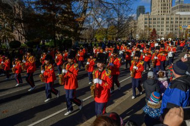 TORONONONONONTO, ONTARIO, CANADA - 23, 2025: Olağanüstü kırmızı (kırmızı) üniformalı ve uzun siyah şapkalı bir bando grubu Toronto şehir merkezindeki Orijinal Noel Baba Geçit Töreni 'ne doğru ilerliyor..
