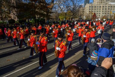 TORONONONONONTO, ONTARIO, CANADA - 23, 2025: Olağanüstü kırmızı (kırmızı) üniformalı ve uzun siyah şapkalı bir bando grubu Toronto şehir merkezindeki Orijinal Noel Baba Geçit Töreni 'ne doğru ilerliyor..