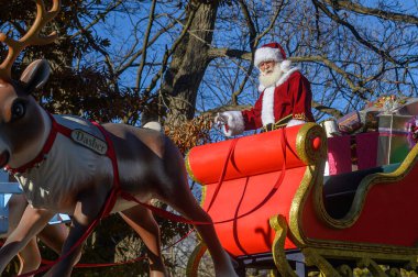 TORONONONONTO, ONTARIO, CANADA - 23 Kasım 2025: Noel Baba, Toronto şehir merkezindeki orijinal Noel Baba Geçit Töreni 'nin finalinde, ikonik kırmızı ve altın kızağına binerken kalabalığa el sallıyor..