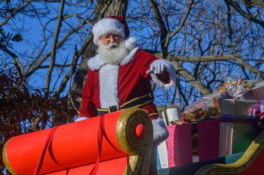 TORONONONONTO, ONTARIO, CANADA - 23 Kasım 2025: Noel Baba, Toronto şehir merkezindeki orijinal Noel Baba Geçit Töreni 'nin finalinde, ikonik kırmızı ve altın kızağına binerken kalabalığa el sallıyor..