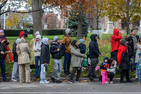 Toronto, ON, Kanada - 23 Kasım 2025: İzleyiciler 121 'inci Noel Baba Geçidi' ni yol kenarından, bayram etkinliği için sıcak giyimli bir şekilde izliyorlar..