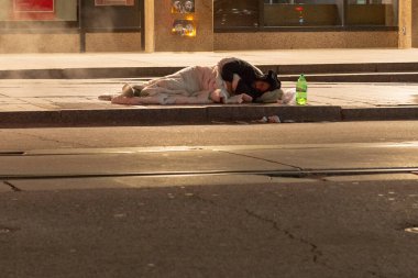Toronto, ON, Kanada - 10 Ocak 2023: Evsiz bir adam kışın ısınmak için battaniyeyle kaplı bir sokakta uyuyor