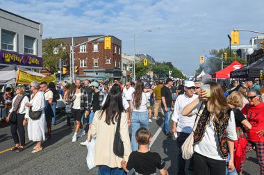Toronto, ON, Kanada - 13 Eylül 2025: Canlı bir sokak festivaline katılan kalabalık, kentsel bir ortamda yemek tezgahları ve kültürel performanslarla