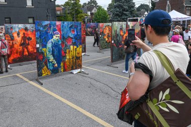 Toronto, ON, Kanada - 13 Eylül 2025: Bir Toronto sokak festivalinde Ukrayna tema ve askerlerini tasvir eden canlı resimler çeken adam