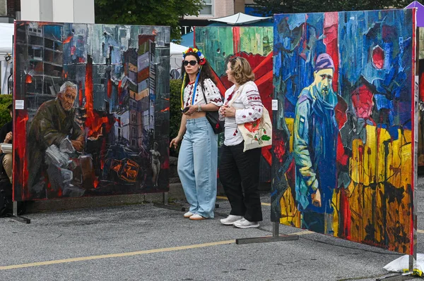 Toronto, ON, Kanada - 13 Eylül 2025: Vyshyvanka 'da kadınlar bir açık hava kültür festivalinde savaşı, çatışmayı ve mücadeleyi tasvir eden güçlü sanat eserlerini izliyorlar