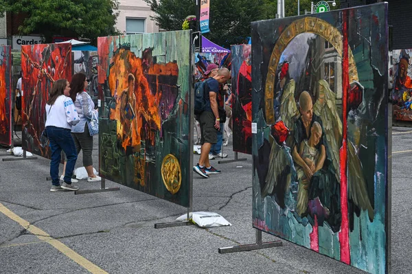 Toronto, ON, Kanada - 13 Eylül 2025: Ukraynalı ressamların açık hava sokak festivalinde kültür ve cemaati kutlayan büyük resimlerini izleyen ziyaretçiler
