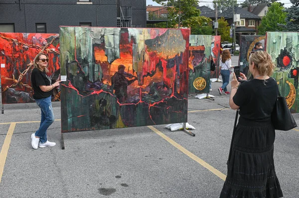 Toronto, ON, Kanada - 13 Eylül 2025: Ukrayna kültür ifadelerinin sergilendiği bir açık hava sokak festivalinde çağdaş sanatı gözlemleyen ve belgeleyen ziyaretçiler