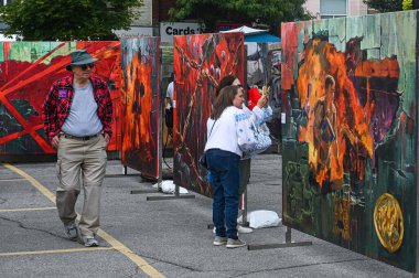 Toronto, ON, Kanada - 13 Eylül 2025: Bloor Ukrayna Festivali 'nde büyük ve renkli soyut resimleri gözlemleyen ziyaretçiler, kültür ve sanatsal ifadeyi kutluyorlar
