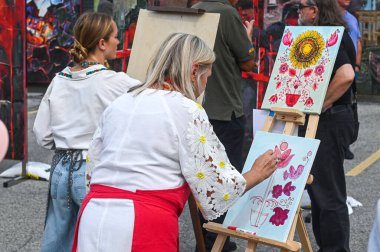Toronto, ON, Kanada - 13 Eylül 2025: Canlı bir sokak festivali sırasında geleneksel Ukrayna halk sanatını sergileyen canlı bir çiçek tablosu yaratan sanatçı