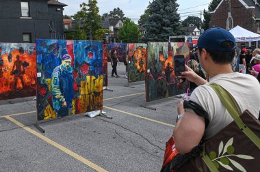 Toronto, ON, Kanada - 13 Eylül 2025: Bir açık hava sokak festivalinde Ukrayna çatışma temalarını resmeden kişi, kültürel ifade ile meşgul