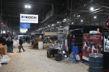 Toronto, ON, Kanada - 14 Kasım 2025: İnsanlar bir tarım fuarı için saman, ekipman ve afişlerle dolu büyük bir sergi salonunda dolaşıyorlar