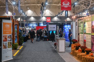 Toronto, ON, Kanada - 14 Kasım 2025: Geleneksel tarım fuarına katılan insanlar, sonbahar temalı sergilerle ve satıcı kabinlerinin önünden geçiyorlar