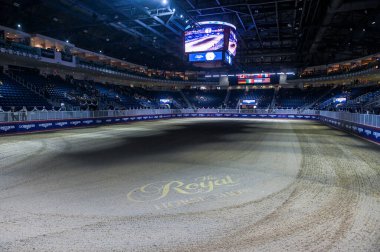 Toronto, ON, Kanada - 14 Kasım 2025: Kum yüzeyinde Royal Horse Show logosu ve boş seyircinin durduğu büyük binicilik arenası bir etkinlik bekliyor