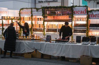 Toronto, ON, Kanada - 14 Kasım 2025: Bir sergide bal kavanozu ve bal şişesi satan satıcılar, Kraliyet Tarım Kış Fuarı 'ndaki müşterilerle iletişime geçtiler