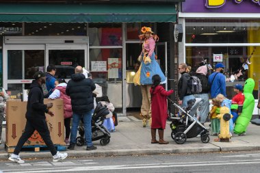 Toronto, ON, Canada - October 25, 2025: People enjoying a vibrant Halloween street festival on Bloor Street, featuring a stilt walker and children in costumes