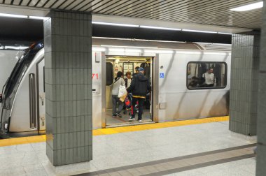 Toronto, ON, Kanada - 6 Aralık 2025: Yolcular yoğun bir istasyon peronunda metroya binip çıkıyorlar.