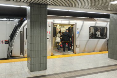 Toronto, ON, Kanada - 6 Aralık 2025: Yolcular yoğun bir istasyon peronunda metroya binip çıkıyorlar.
