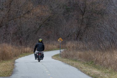 Toronto, ON, Kanada - 15 Ekim 2025: Uçsuz bucaksız sonbahar ormanlarında tek tekerlekli bisiklet süren, serin mevsim yolculuğunda doğayı dengeleyen ve keşfeden kişi