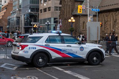 Toronto, ON, Kanada - 15 Ekim 2025: Bir şehir caddesinde mavi ışıkları yanıp sönen özel polis aracı, kamu güvenliği ve emniyet görevlerine hazır