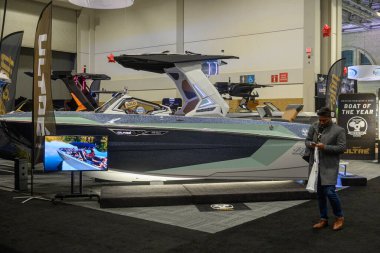 Toronto, ON, Kanada - 20 Ocak 2026: Geleneksel Toronto Uluslararası Boat Show 'a katılan insanlar, satılık bir tabelayla modern bir eğlence teknesini izliyorlar