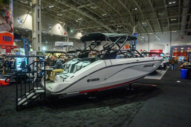 Toronto, ON, Kanada - 20 Ocak 2026: New Yamaha 222X teknesi büyük bir deniz sergisinde boş zamanlarını değerlendiren bir adamla birlikte sergileniyor