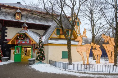 Toronto, ON, Kanada - 31 Aralık 2025: Kanada 'nın Harikalar Diyarı Kış Festivali' nde kar yağışı sırasında bir binayı süsleyen yılbaşı süsleri ve aydınlatılmış ren geyiği heykelleri